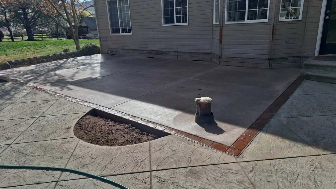 Finished stamped concrete patio with a brick border