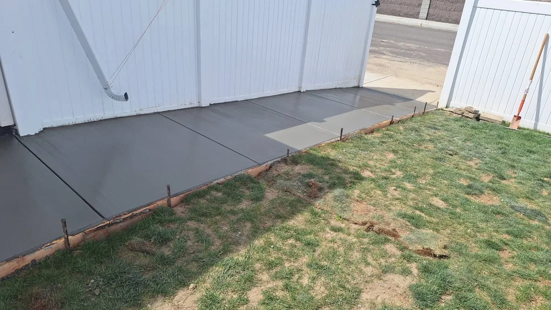 Freshly finished concrete walkway along a home